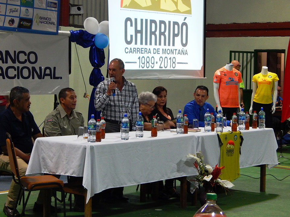 Persona dando discurso rodeado de representantes durante Carrera Chirripó 2018