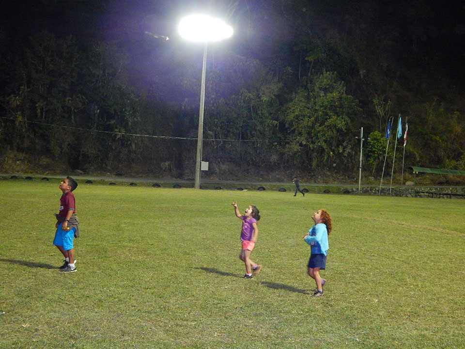 niños jugando en cancha durante la noche