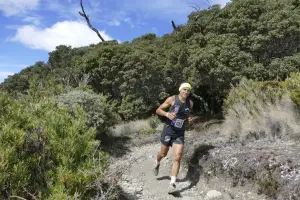 Corredor sonriendo mientras avanza en sendero en medio de la naturaleza del Parque Nacional Chirripó