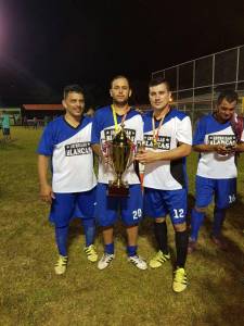 3 miembros de un equipo posando con un trofeo