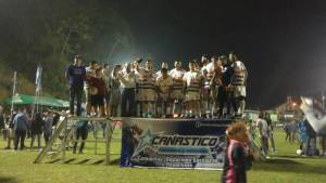 Equipo de futbol sobre tarima posando en la noche