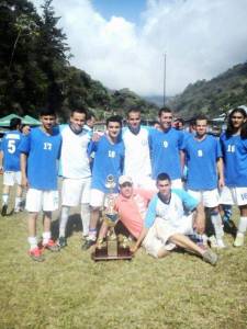 Miembros de equipo de futbol posando con un trofeo