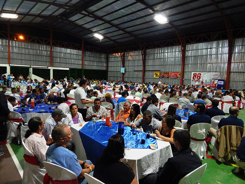 Personas sentadas en muchas mesas en cena de gala