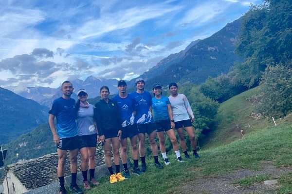 7 corredores posando con montañas de fondo